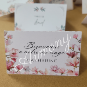 Marque-place mariage fleuri avec texte "Bienvenue à notre mariage", fleurs roses et calligraphie élégante