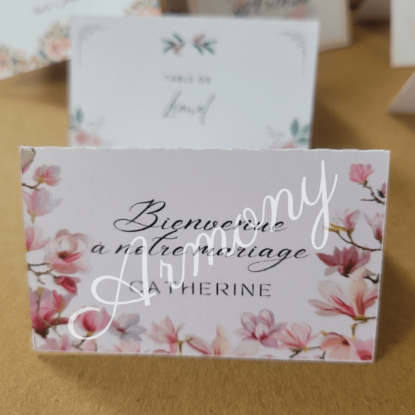 Marque-place mariage fleuri avec texte "Bienvenue à notre mariage", fleurs roses et calligraphie élégante